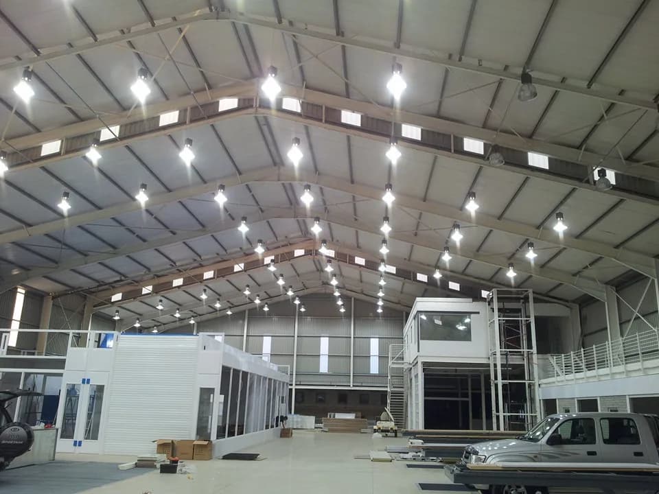 Commercial warehouse roof structure with electrical lighting installation in progress